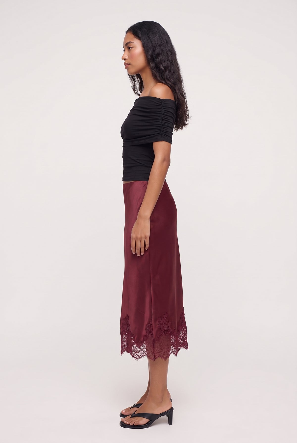 [BURGUNDY] model wearing LUCIA LACE SLIP SKIRT posing Side View